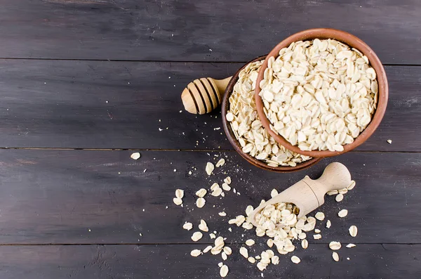 Fiocchi d'avena in ciotola di ceramica, in paletta di legno — Foto Stock