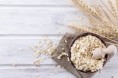 Yulaf gevreği seramik kase ve tahta kaşık ve spikelets 