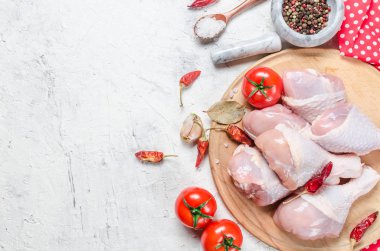 Baharat ve otlar ile kesme tahtası üzerinde çiğ tavuk budu.