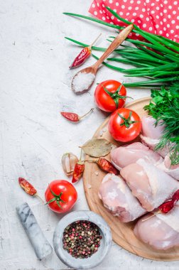 Baharat ve otlar ile kesme tahtası üzerinde çiğ tavuk budu.