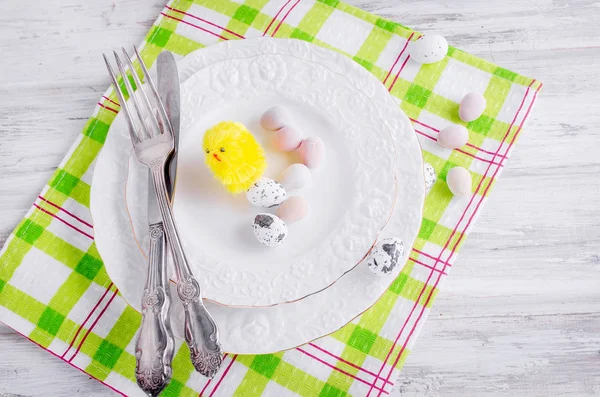 Polluelo amarillo pequeño y juguetes decorativos huevos en el plato —  Fotos de Stock