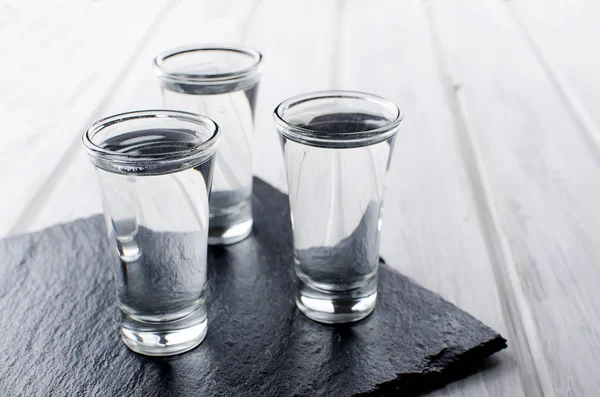 Vodka tiros na mesa branca — Fotografia de Stock