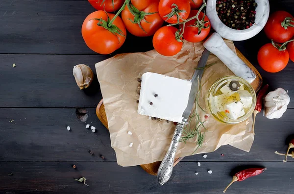 Trozo de queso blando en el tablero y feta picante marinada en un —  Fotos de Stock