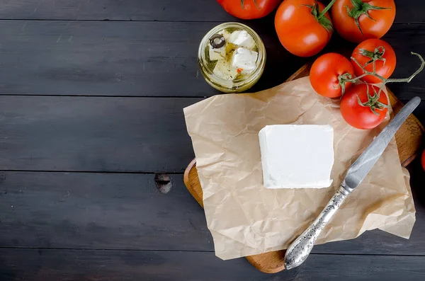 Trozo de queso blando en el tablero y feta picante marinada en un —  Fotos de Stock