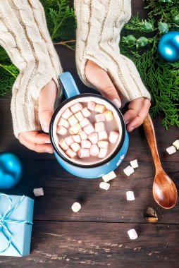 Çocuk Noel ortamında bir fincan sıcak kakao tutuyor.