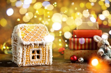 İçinde zencefilli ev hediyeleri ve ışıklar olan Noel kartı.