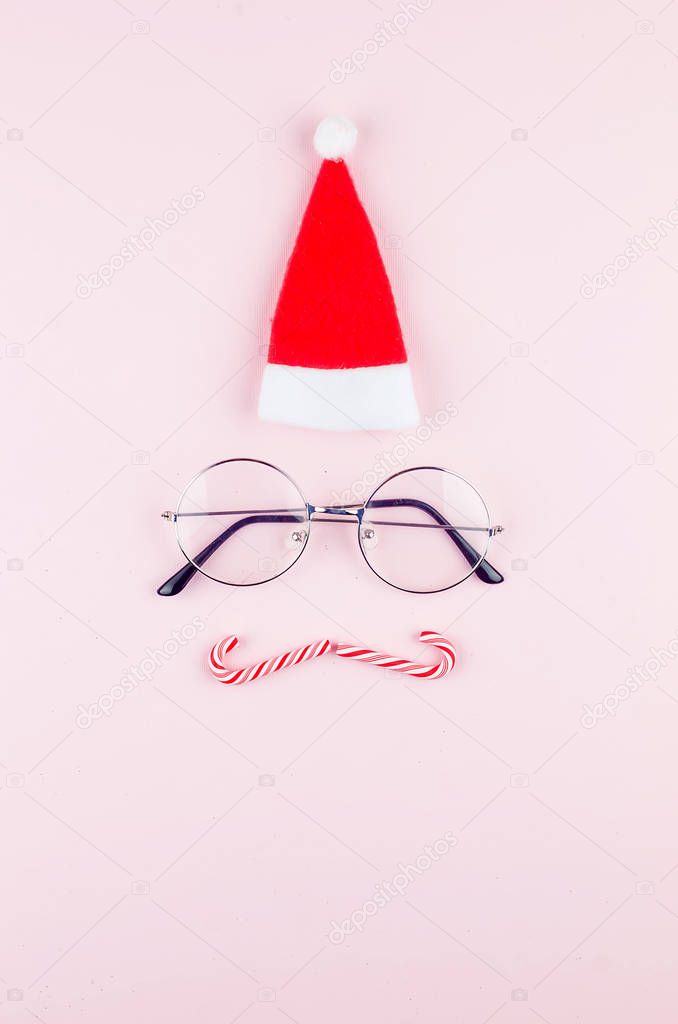 improvised image of Santa from a hat and glasses on pink