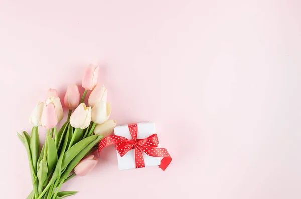Caja de regalo con ramo de tulipanes sobre fondo rosa pastel . — Foto de Stock