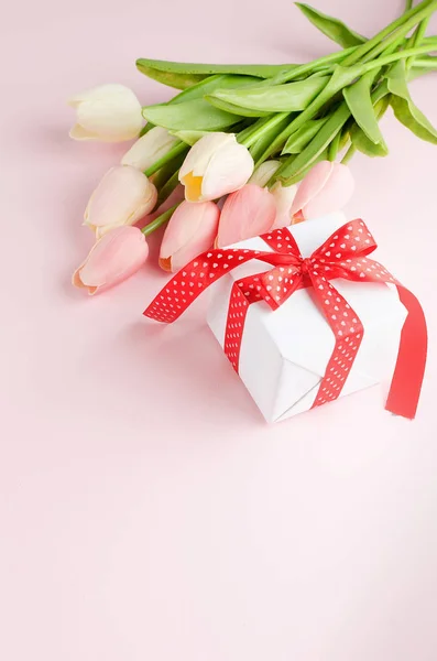 有一束郁金香和粉红背景的礼品盒 图库照片 C Vi Mart