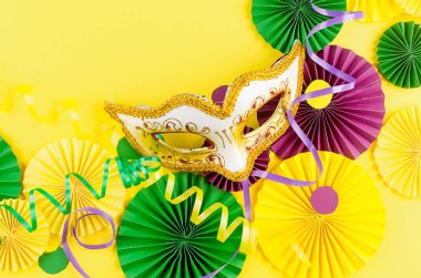 Renkli kağıt konfetileri, karnaval maskesi ve sarı arka planda fotokopi alanı, tebrik kartı ve karnaval ya da doğum günü için parti davetiye şablonu tasarımı, Mardi Gras,