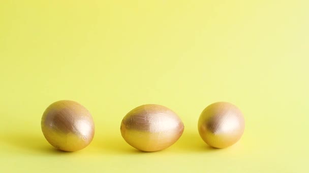 Gold Decorative Eggs Rolling Knock Each Other Yellow Background Spring — Stock Video