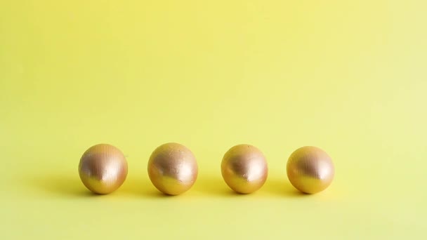 Huevos Decorativos Oro Rodando Golpearse Entre Fondo Amarillo Concepto Vacaciones — Vídeos de Stock