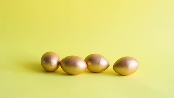 Huevos Decorativos Oro Rodando Golpearse Entre Fondo Amarillo Concepto Vacaciones — Vídeo de stock