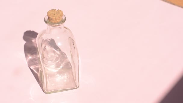 Leere Glasflasche Mit Korken Auf Rosa Hintergrund Mit Schatten Unter — Stockvideo