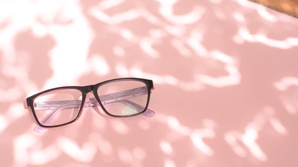 Lunettes Sur Fond Rose Avec Ombres Sous Lumière Naturelle Journée — Video