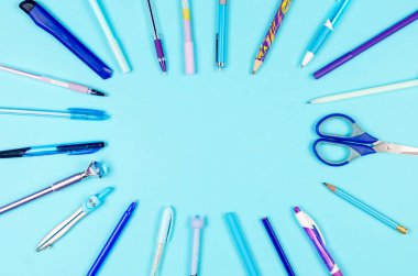 Not defteri, mavi ve leylak rengi okul malzemeleri mavi arka planda. Eğitim konsepti. Kopyalama alanı ile yukarıdan görüntüle. Model, düz yat..