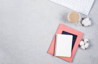 İçinde not defterleri, boş kağıtlar, malzemeler, bardaklar ve bir fincan kahve olan gri çalışma masası. Metnin için en üstte boşluk var. Düz yatıyordu. Asgari tarz ev ofisi ya da Modern Serbest İşyeri.