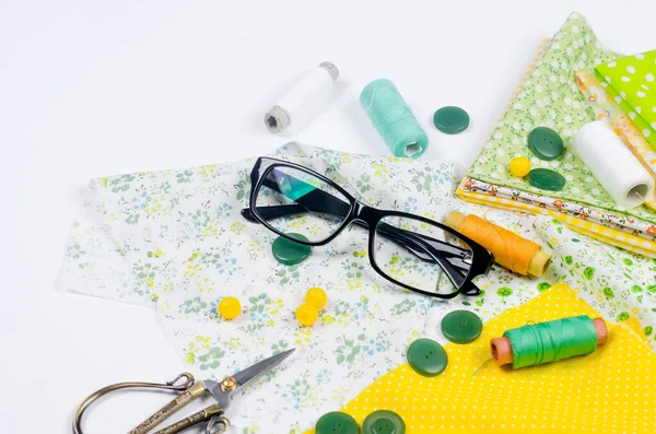 Set Colorful Yellow Green Fabrics Scissors Buttons Spools Thread Glasses — Stock Photo, Image