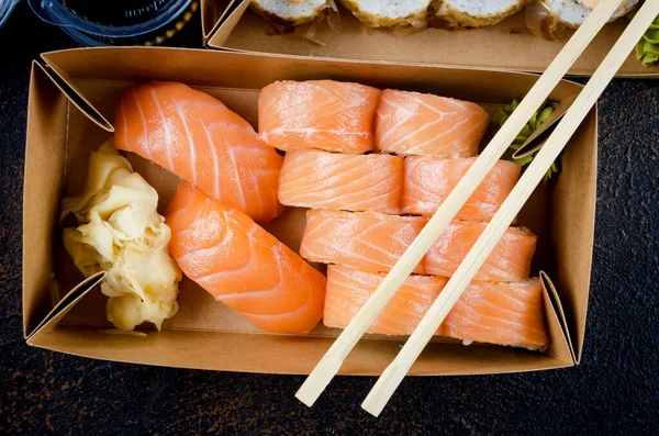 Rolos de sushi saborosos em caixas de papel kraft descartáveis, molhos, pauzinhos. Sushi para levar ou entrega — Fotografia de Stock