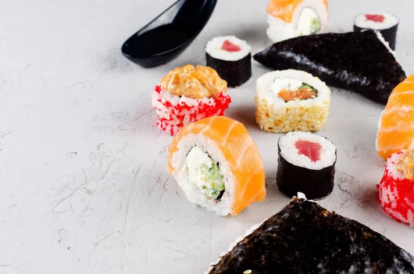 将不同的寿司和酱油 芥末和筷子放在灰色的混凝土桌子上 寿司菜单 日本食品递送服务 趋势混合食品 — 图库照片