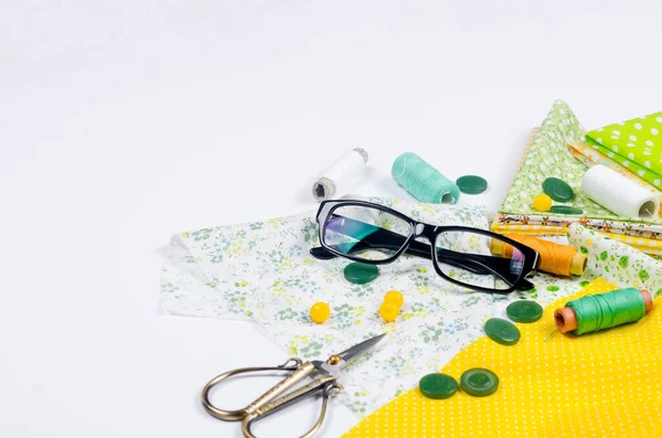 Conjunto Coloridas Telas Amarillas Verdes Tijeras Botones Carretes Hilo Gafas —  Fotos de Stock