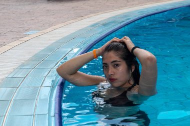 Kız otel havuzunda iyi vakit geçiriyor.