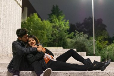 Genç aşıklar güzel bir gece geçiriyorlar merdivenlerde oturup konuşuyorlar.