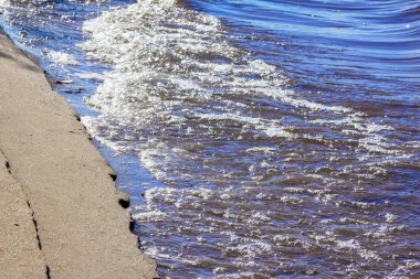 Kumlu sahile yakın su ile yıkanır
