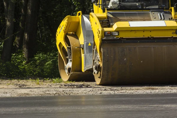 Yol silindiri arka planı yeşil ağaçlar yolun kenarında duruyor