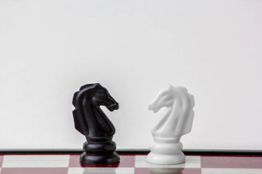 Satranç siyah ve beyaz at yüz yüze. Beyaz arka plan üzerinde izole.