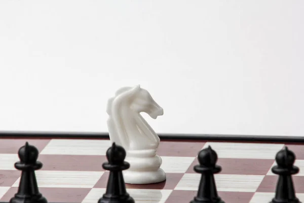 siyah piyonlar önünde satranç beyaz at. mücadele kavramı. Beyaz arka plan üzerinde izole.
