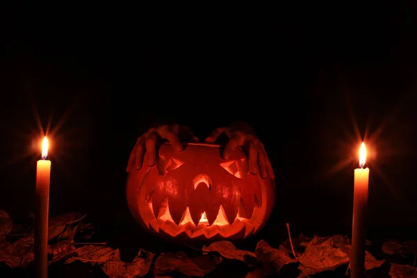 Хелувин страшная Хэллоуинская тыква с руками, лежащими на ней . — стоковое фото