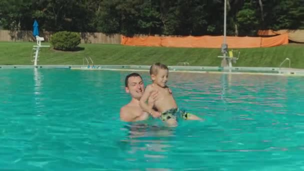 Ojciec i jego syn bawią się w basenie. Szczęśliwy, słodki. — Wideo stockowe