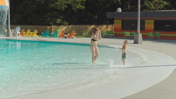 Mutter und ihr kleiner Sohn amüsieren sich im Schwimmbad — Stockvideo