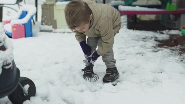 Kleine jongen spelen in de sneeuw en lachen in de winter — Stockvideo