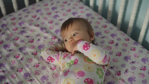 Χαριτωμένο κοριτσάκι στο κρεβάτι του μωρού — Αρχείο Βίντεο