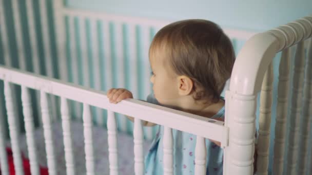 Schattig baby meisje in de baby bed — Stockvideo