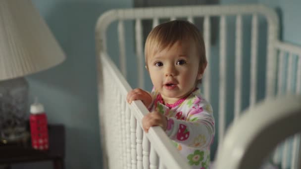 Linda niña en la cama de bebé — Vídeos de Stock