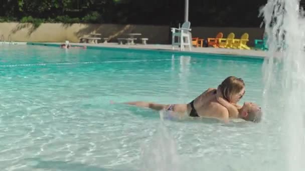 Moeder en haar zoontje hebben plezier in een zwembad — Stockvideo