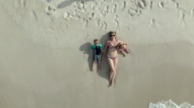 Aile kumsalda yatıyordu. Havadan görünüşlü drone görüntüsü.