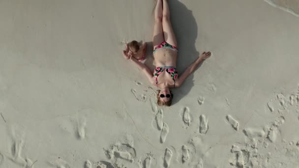 彼女の赤ちゃんの女の子とビーチで横たわっ女性の空中ビュー — ストック動画
