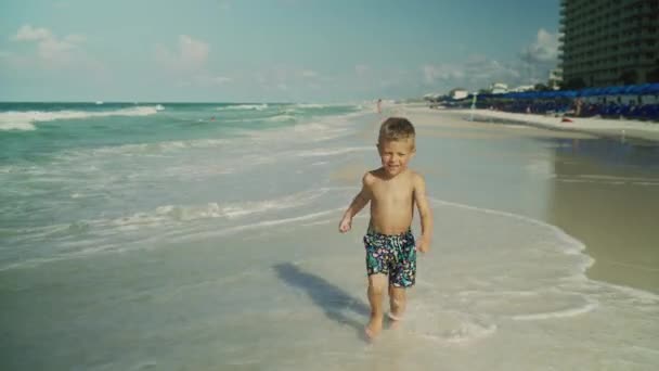 Kleine jongen loopt langs het strand van de oceaan in de zomer op het Panama City Beach Usa — Stockvideo