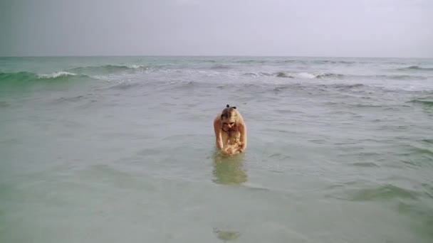 Jovem mãe feliz e sua menina se divertem na água do oceano na Praia da Cidade do Panamá EUA — Vídeo de Stock