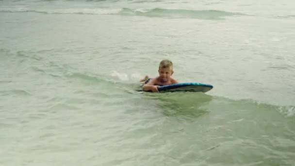 Kleiner Junge mit Surfbrett, der Spaß im Meer hat. panama city beach usa — Stockvideo