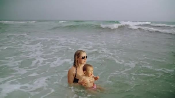 Glückliche junge Mutter und ihr kleines Mädchen haben Spaß im Wasser des Ozeans am panama city beach usa — Stockvideo