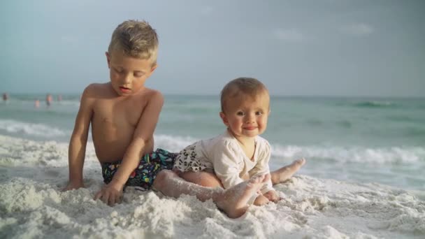 Pequena menina engraçada e seu irmão mais novo na praia. Panamá City Beach EUA — Vídeo de Stock