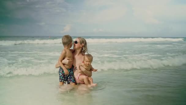 Feliz joven divirtiéndose con sus pequeños niños en el agua del océano en Panama City Beach USA — Vídeo de stock