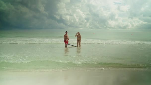 Счастливая молодая семья веселится в океанской воде на пляже Панама Сити — стоковое видео