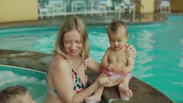 La joven madre y sus hijos en la piscina. Niña y su hermano se divierten con su madre en la piscina — Vídeos de Stock