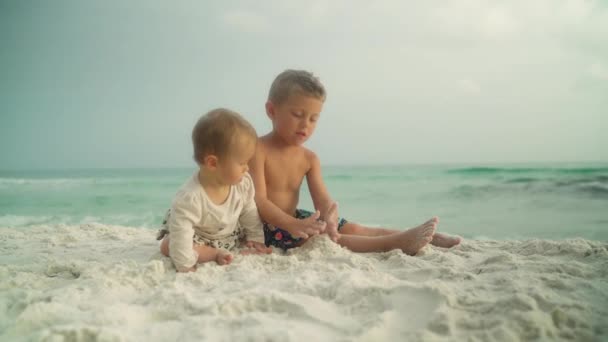 A kis vicces kislány és a kisöccse a parton. Panama City Beach Egyesült Államok — Stock videók